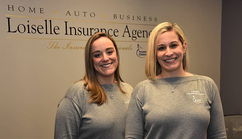 two women standing in front of a wall that says Loiselle Insurance Agency