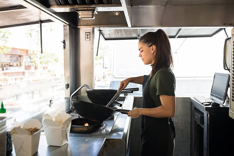 a cook works behind the stove of a food truck 