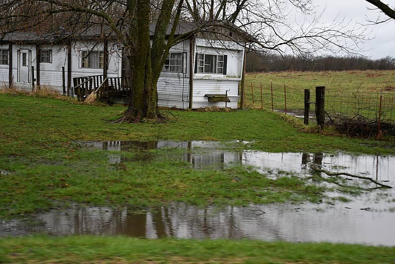 mobile or manufactured home with flooded lawn threatening home