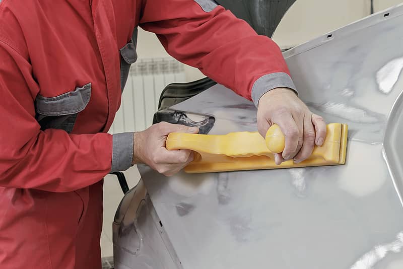 auto body repair man fixing a vehicle involved in an accident