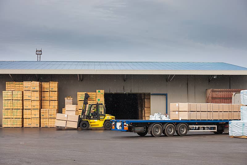 forklift loading wood onto commercial truck