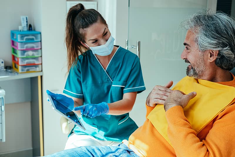 dental hygienist discussing dental options with patient