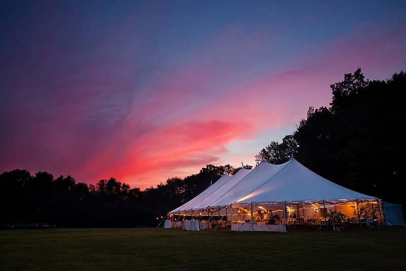 outdoor tent, table, and chairs set up for wedding reception