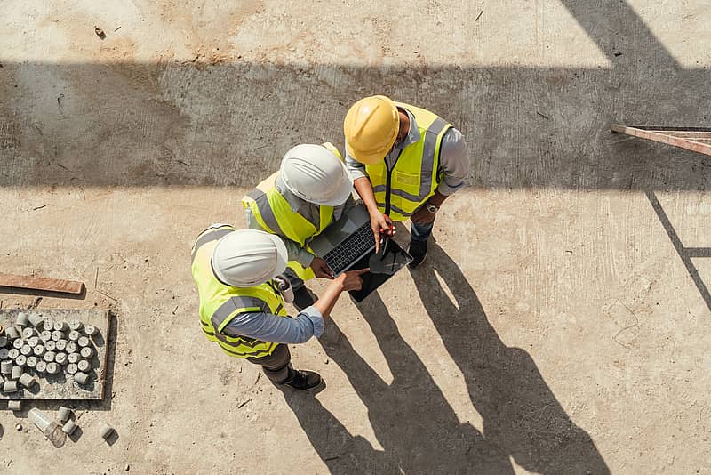 aerial view of construction workers looking at tablet