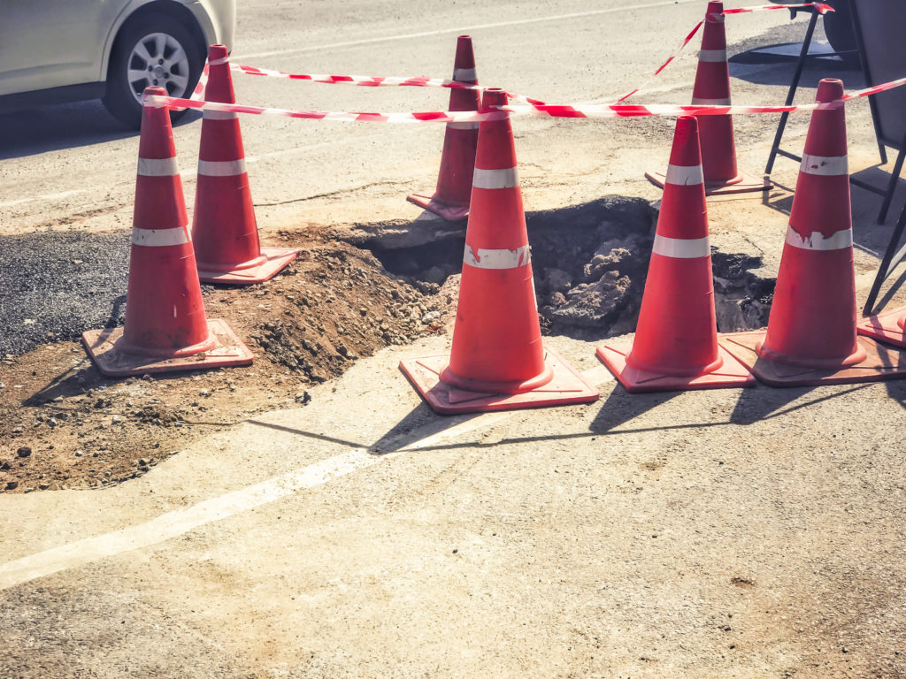 cone blocking a damaged road