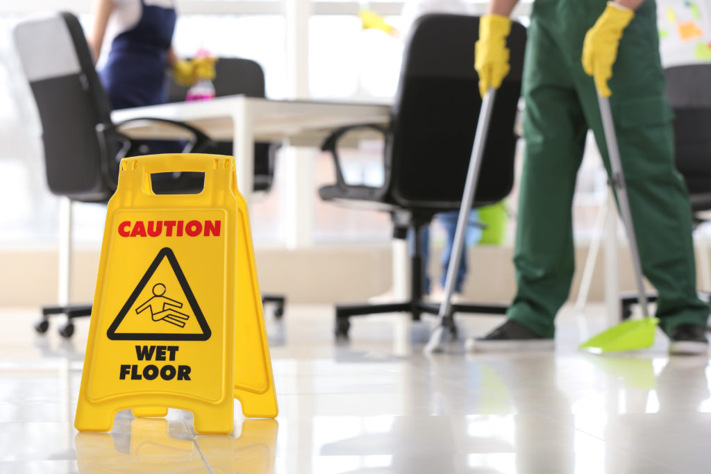 a wet floor sign sits on a freshly mopped floor 