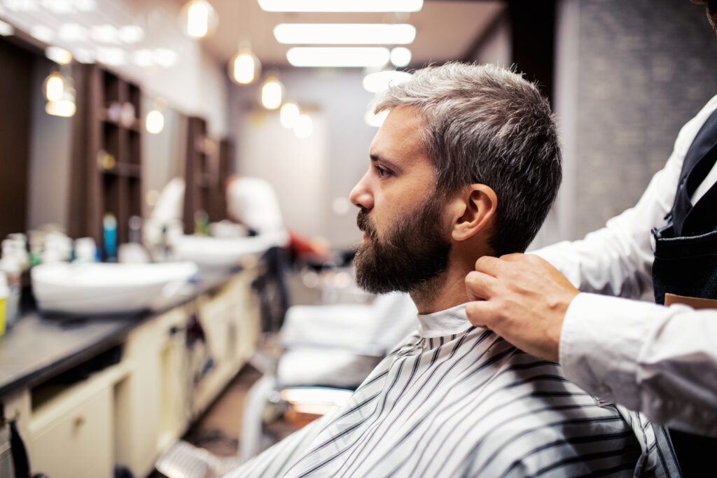 a man wearing a cape in a barber shop 