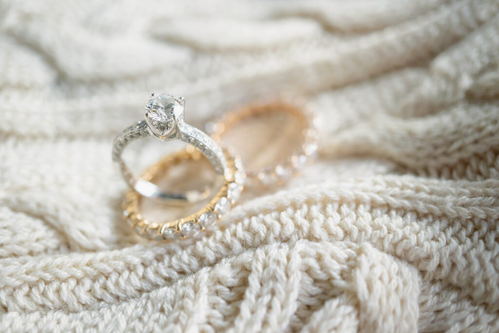 Close up of engagement ring and wedding ring on sweater