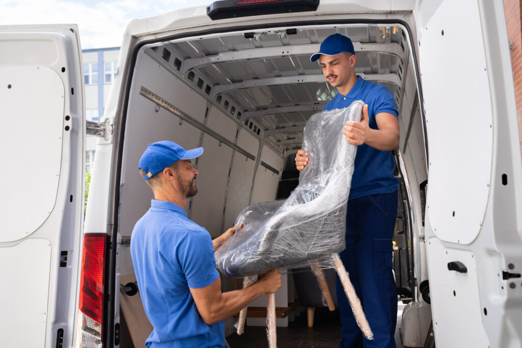 movers loading a chair into a moving van 