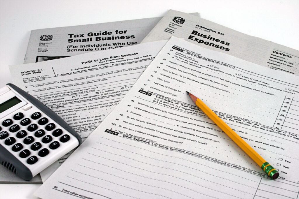 IRS Business Tax forms and instructions with pencil and calculator