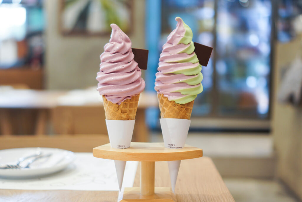 two ice cream cones sit on a counter at an ice cream shop