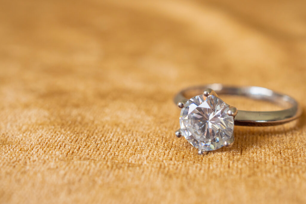 close up of diamond ring sitting on fabric