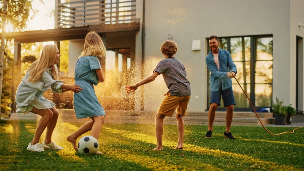 happy family playing soccer outside