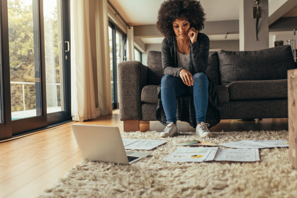 woman working on her home based business looking at papers spread out on the floor