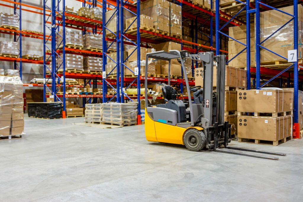 a warehouse with a forklift moving boxes