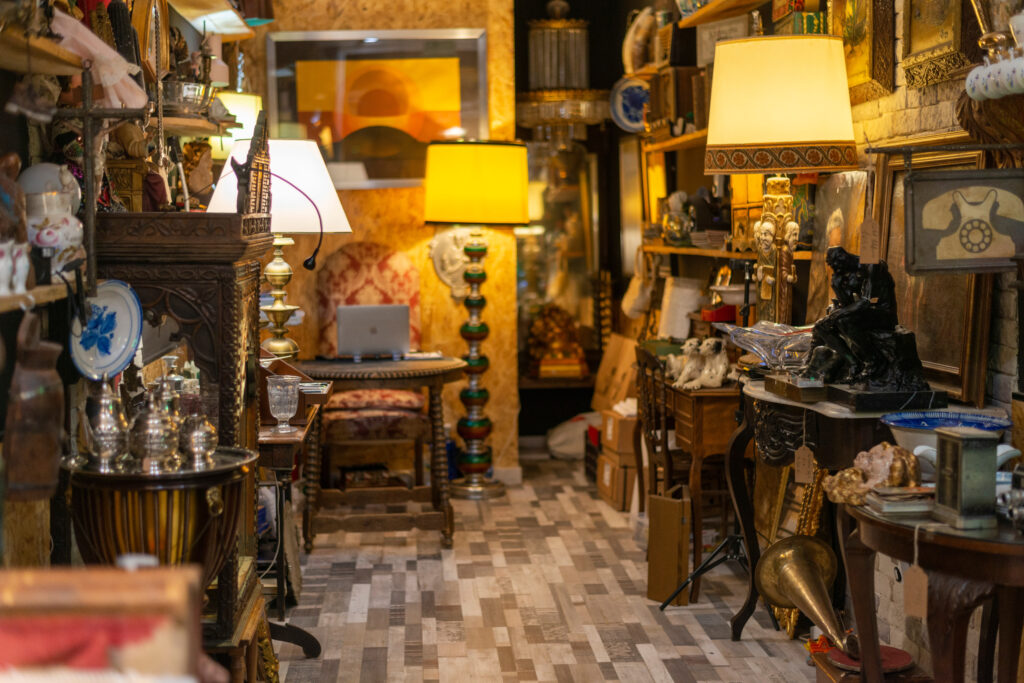 the interior of an antique shop showing shelves of goods and lamps