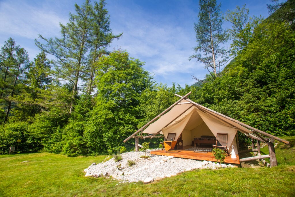 glamping tent with chairs and other amentities in a wooded area